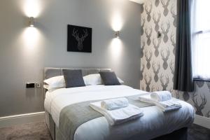 a bedroom with a large bed with towels on it at The Glebe Hotel in Liverpool