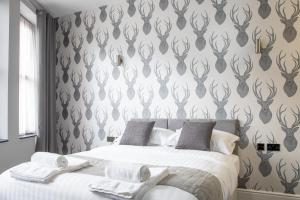 a bedroom with a bed with a black and white wallpaper at The Glebe Hotel in Liverpool