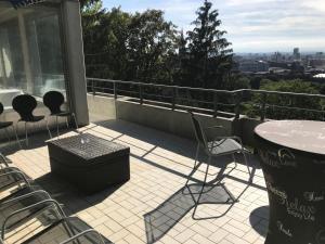 d'une terrasse avec une table et des chaises sur un balcon. dans l'établissement Ferienwohnung-Freiburg-Exklusiv, à Fribourg-en-Brisgau