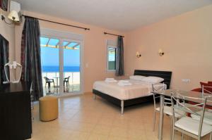 a bedroom with a bed and a view of the ocean at Blue Horizon Studios in Skala Kallirachis