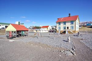 a group of birds sitting on the gravel in front of a house at Hotel Hvammstangi Guesthouse in Hvammstangi