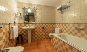 La salle de bains est pourvue d'un lavabo, d'une baignoire et de toilettes. dans l'établissement Hotel Rural Los Angeles en Las Hurdes, à Vegas de Coria