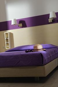 Una cama púrpura con sombrero y gafas de sol. en Danae Villas, en Hersonissos