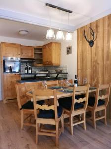 een keuken met een houten eettafel en stoelen bij Superbe appt 2 chambres Arc 1950 in Arc 1950