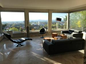 ein Wohnzimmer mit einem Sofa und einem Stuhl in der Unterkunft Ferienwohnung-Freiburg-Exklusiv in Freiburg im Breisgau