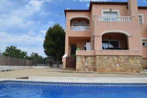 a villa with a swimming pool in front of a house at CASA BRISA in Les tres Cales