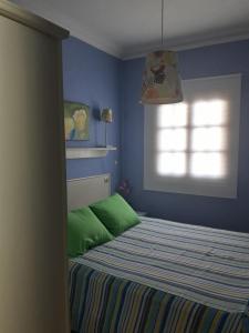 een slaapkamer met een bed met groene lakens en een raam bij Casa Costa Amanecer in Punta de Mujeres