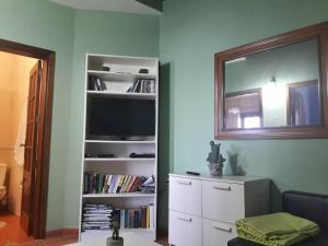 sala de estar con TV y estante de libros en Casa Costa Amanecer, en Punta Mujeres