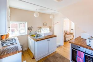 a kitchen with a sink and a stove top oven at 5 Coastguard Cottages in Aldeburgh