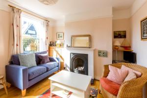 ein Wohnzimmer mit Couch und Kamin in der Unterkunft 5 Coastguard Cottages in Aldeburgh