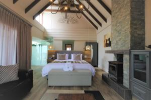 a bedroom with a large bed and a fireplace at Dolphin Dunes Guesthouse in Wilderness