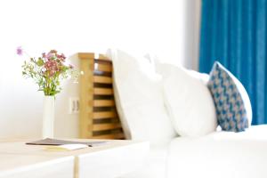 un divano bianco con un vaso di fiori su un tavolo di Hôtel & Restaurant Le Pré a Durtol