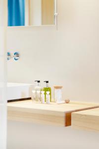 a bathroom counter with a sink and a mirror at Hôtel & Restaurant Le Pré in Durtol