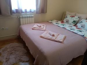 a bedroom with a bed with two towels on it at Apartman Nina Vojvode Stepe Vozdovac in Voždivac
