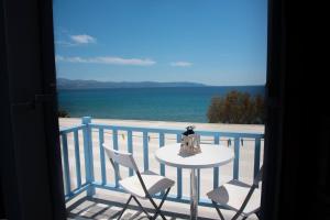 a balcony with a table and chairs and the ocean at Fisilanis Beachfront Hotel in Logaras