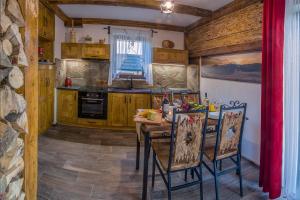 a kitchen with a table and chairs in a room at Jaworczański Raj pod Wysoką - z Sauną przy Wyciągu in Szczawnica