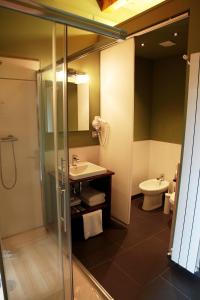 a bathroom with a shower and a sink and a toilet at Hotel Araz in Las Rozas de Valdearroyo