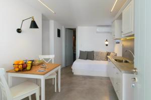 a kitchen with a table and a room with a bed at L’arco Milos Suite in Adamantas