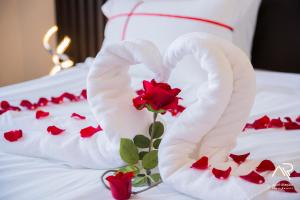Aspar Resorts في الرياض: سرير فيه بجعتين شكله زي الورد