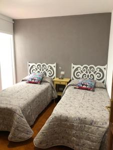 a bedroom with two beds and a window at Apartamento playa arinaga in Arinaga