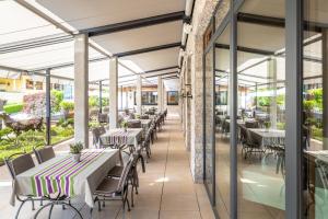 a dining room with tables and chairs and windows at Cocoon - Alpine Boutique Lodge in Maurach