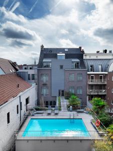a large swimming pool in the middle of buildings at Hotel Harmony in Ghent