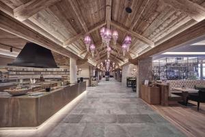 un ristorante con un grande soffitto in legno e un lampadario a braccio di Cocoon - Alpine Boutique Lodge a Maurach