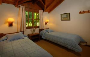 Una cama o camas en una habitación de Pailahue Cabañas Lodge