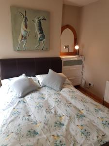 a bedroom with a bed and a painting of rabbits at Derry City center townhouse in Derry Londonderry