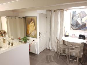 uma sala de estar com uma mesa e um quadro na parede em Chambre d'Hôte - Mas Le Barret em Arles