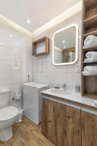 a bathroom with a toilet and a sink and a mirror at TriApart Cozy in Gdańsk