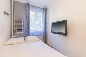 a bedroom with two beds and a flat screen tv at TriApart Cozy in Gdańsk