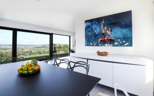 Frasnes-lez-AnvaingVilla Les Hauts的厨房配有桌椅和墙上的绘画作品