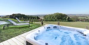 a hot tub on a wooden deck with a bench at Villa Les Hauts in Frasnes-lez-Anvaing