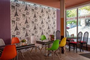 Family Hotel Varna في مدينة فارنا: مطعم ذو كراسي ملونة وطاولة مع ستارة