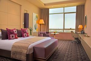 um quarto de hotel com uma cama grande e uma secretária em Erbil Rotana em Erbil