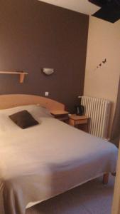 um quarto com uma cama branca e duas mesas em Hotel de la Gare em Noyers-sur-Cher