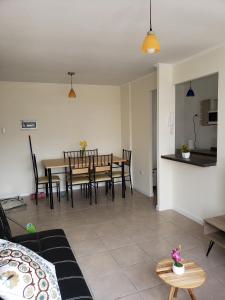 ein Wohnzimmer mit einem Tisch und Stühlen sowie eine Küche in der Unterkunft Depto Piso 4 Altos del Brillador in La Serena