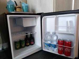 an open refrigerator with drinks and cans of soda at Acquasalata in Salerno