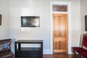 a living room with a table and a door at Crescent City Cottage in New Orleans