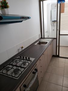 una cocina con estufa y fregadero en Depto Piso 4 Altos del Brillador, en La Serena