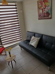 ein blaues Sofa im Wohnzimmer mit einem Tisch in der Unterkunft Depto Piso 4 Altos del Brillador in La Serena