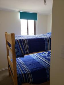 Dos literas en una habitación con ventana. en Depto Piso 4 Altos del Brillador, en La Serena