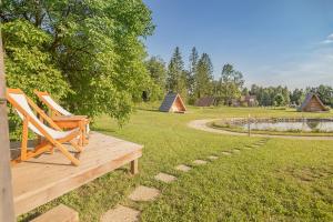 un par de sillas sentadas en una terraza de madera en un campo en Glamping Bizjak, en Preddvor