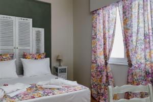 1 dormitorio con 1 cama y una ventana con cortinas en Athens Flower Apartment, en Atenas