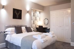 a bedroom with a large bed with towels on it at The Glebe Hotel in Liverpool