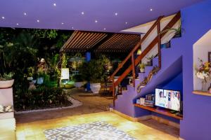 a house with a purple wall and a patio at Pousada Arriba Pipa in Pipa