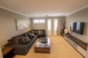 a living room with a couch and a coffee table at Magnificent Beach Retreat in Jindalee