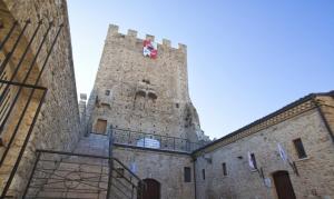 un grande edificio con una torre dell'orologio sopra di Castel di Pietra a Pietra Montecorvino
