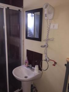 a bathroom with a sink and a shower with a hair dryer at Cabaña Gesell in Puerto Natales